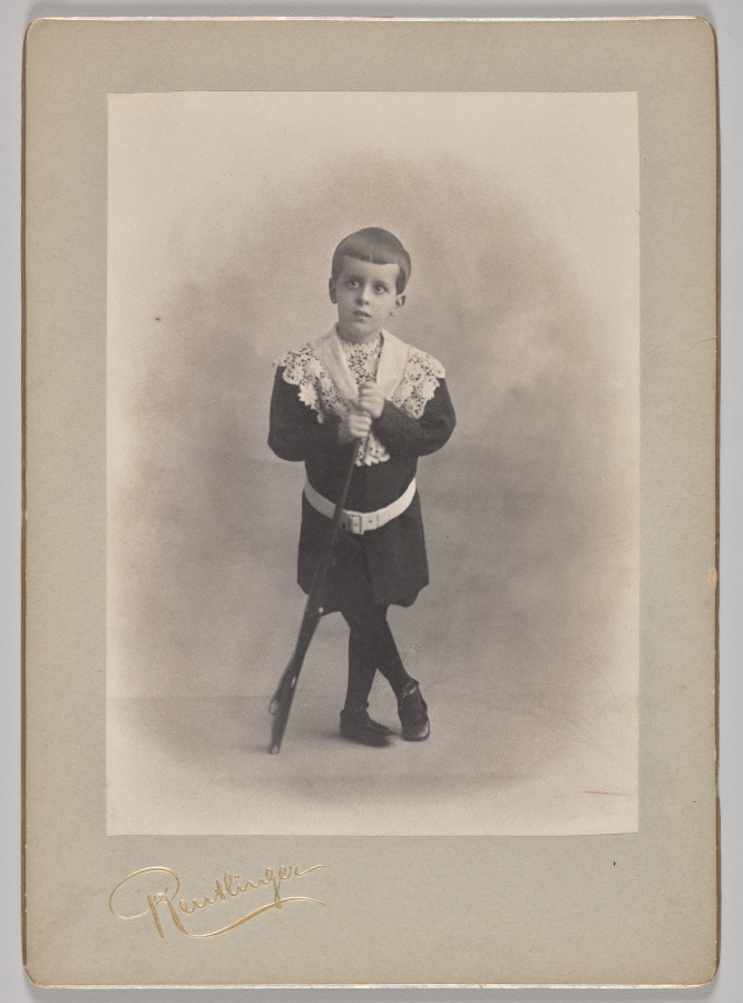 Untitled (young boy with lace collar and toy rifle)
